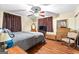 Well-lit bedroom with wood-look flooring, a ceiling fan, and comfortable furnishings at 1115 Highway 54 East, Fayetteville, GA 30214