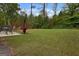 Large backyard with green grass, trees, and a patio with seating, perfect for outdoor entertaining at 9068 Jim Purcell Dr, Covington, GA 30014