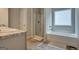 Bright bathroom featuring a bathtub, enclosed shower, and a vanity with a marble countertop at 9068 Jim Purcell Dr, Covington, GA 30014