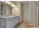 Bathroom with a double sink vanity with marble countertops, white cabinets and tile floor at 9068 Jim Purcell Dr, Covington, GA 30014