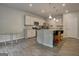 Modern eat-in kitchen featuring stainless steel appliances, granite countertops, stylish lighting, and a breakfast bar with seating at 9068 Jim Purcell Dr, Covington, GA 30014