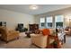 Cozy living room featuring neutral-toned furniture, a bar area, plush carpeting, and ample natural light creating a comfortable space at 9068 Jim Purcell Dr, Covington, GA 30014