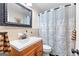 This cozy bathroom includes a stylish vanity with a framed mirror and a patterned shower curtain at 1119 Highway 54 East, Fayetteville, GA 30214