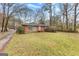 Charming brick home featuring a well-maintained lawn and mature trees at 1119 Highway 54 East, Fayetteville, GA 30214