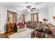 Cozy living room with carpet, fan, striped sofa, curtains and wood accent table at 1119 Highway 54 East, Fayetteville, GA 30214