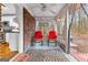 Relaxing enclosed porch with rocking chairs, brick accents, and view of natural landscape at 1119 Highway 54 East, Fayetteville, GA 30214