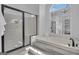 Contemporary bathroom featuring a frameless glass shower and soaking tub under a large window at 407 Blue Smoke Trl, Peachtree City, GA 30269
