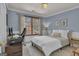 Cozy bedroom with blue walls, carpet, a home office, and a large window offering natural light at 407 Blue Smoke Trl, Peachtree City, GA 30269