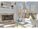 Bright living room featuring a stone fireplace, white sofa, and natural light from the windows at 407 Blue Smoke Trl, Peachtree City, GA 30269