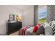 Well-lit staged bedroom featuring racing-themed decor, checkered curtains, and a view to the backyard at 362 Friendship Oak Way, Hampton, GA 30228