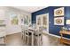 Bright dining room featuring contemporary decor, a blue accent wall, and natural light from windows at 362 Friendship Oak Way, Hampton, GA 30228