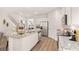 Open eat-in kitchen featuring an island with bar seating, stainless appliances, and wood flooring at 362 Friendship Oak Way, Hampton, GA 30228