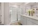 Bright bathroom with a glass shower, double sink vanity with white cabinets and white marble countertops at 358 Friendship Oak Way, Hampton, GA 30228