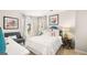 Cozy bedroom featuring bright windows, floral artwork, and a comfortable seating area at 358 Friendship Oak Way, Hampton, GA 30228