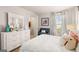 Bedroom featuring bright windows, floral artwork, and a white dresser at 358 Friendship Oak Way, Hampton, GA 30228