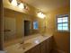 Large bathroom featuring double sinks, a large mirror, a window, and plenty of cabinet space at 312 Villa Place Ct, Tucker, GA 30084