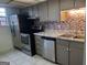 Kitchen featuring stainless steel appliances, gray cabinets and tile backsplash at 746 Dunaire Way, Jonesboro, GA 30238
