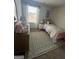 Charming bedroom with decorative rug, dresser, bedside table, and natural light at 11563 Kimberly Way # 23, Hampton, GA 30228
