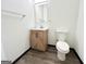 Bathroom with modern vanity, mirror, and toilet with neutral paint color and wood look flooring at 6159 Sable Fox Dr, Riverdale, GA 30296