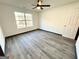 Bedroom with wood look floors, large window, ceiling fan, and white trim at 6159 Sable Fox Dr, Riverdale, GA 30296