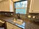 Close-up of a kitchen sink with a modern faucet, granite countertops, and tile backsplash, adding elegance to the space at 6159 Sable Fox Dr, Riverdale, GA 30296