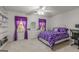 Bright bedroom features neutral walls, carpet, and purple patterned bedding for a relaxing atmosphere at 105 Queens Gate, Fayetteville, GA 30215