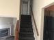 Carpeted stairs lead to the upper level with a fireplace view at 1574 Elizabeth Ln, Hampton, GA 30228