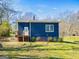Back of blue home featuring a wooden deck and stairs in a serene setting at 340 Cedar St, Social Circle, GA 30025