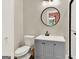 A gray bathroom with a round mirror and a view into a pink Bedroom from the doorway at 340 Cedar St, Social Circle, GA 30025