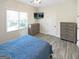 A well-lit bedroom offers wood-look tile floors, a ceiling fan, and a mounted TV at 340 Cedar St, Social Circle, GA 30025