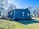 Rear view of a quaint blue home with ample lawn space and neat landscaping at 340 Cedar St, Social Circle, GA 30025