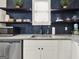 Modern kitchen features open shelving, granite countertops, stainless appliances and stylish herringbone tile backsplash at 340 Cedar St, Social Circle, GA 30025