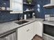 Kitchen with granite countertops, stainless steel appliances, herringbone backsplash, and sleek fixtures offers style at 340 Cedar St, Social Circle, GA 30025