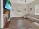 Inviting living room with wood-look tile floors, fireplace, and light gray sectional sofa offers a relaxed atmosphere at 340 Cedar St, Social Circle, GA 30025