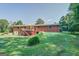 Back of a brick home with a wooden deck and a spacious backyard at 677 Gum Creek Rd, Oxford, GA 30054