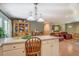 Open kitchen with island, lighting, and wood cabinets opening to a sitting area, and a living room at 677 Gum Creek Rd, Oxford, GA 30054