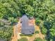 An aerial view of a wooded property with the house featuring a spacious deck among mature trees at 2643 Rocky Creek Rd, Hampton, GA 30228