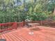 View of back deck with grill and table in treed backyard at 2643 Rocky Creek Rd, Hampton, GA 30228