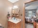 Bathroom with a wood cabinet, sink, mirror, and doorway to a bedroom, providing a functional space at 2643 Rocky Creek Rd, Hampton, GA 30228