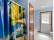 Bright bathroom with a tropical themed shower curtain, with a neutral colored toilet and shower at 2643 Rocky Creek Rd, Hampton, GA 30228