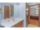 Light blue bathroom with a wide mirror, wooden door frame, and a glimpse into the bedroom at 2643 Rocky Creek Rd, Hampton, GA 30228