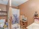 Rustic bathroom featuring a shower with a whimsical shower curtain, toilet, and small vintage table at 2643 Rocky Creek Rd, Hampton, GA 30228