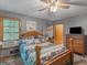 Comfortable bedroom featuring a decorative bed frame, wooden furniture, and lots of storage at 2643 Rocky Creek Rd, Hampton, GA 30228