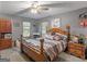Comfortable bedroom featuring a decorative wooden bed frame, side tables, and lots of natural light at 2643 Rocky Creek Rd, Hampton, GA 30228