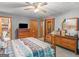 Comfortable bedroom featuring a decorative bed frame, wooden furniture, and lots of storage at 2643 Rocky Creek Rd, Hampton, GA 30228
