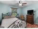 Cozy bedroom features a metal-frame bed, dresser with TV, and a window with natural light at 2643 Rocky Creek Rd, Hampton, GA 30228