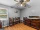 Spacious bedroom featuring a vintage ceiling fan, hardwood floors, and classic furniture pieces at 2643 Rocky Creek Rd, Hampton, GA 30228