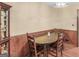 Traditional dining area featuring a wooden table set with chairs, and decorative wainscoting at 2643 Rocky Creek Rd, Hampton, GA 30228
