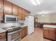 Bright kitchen featuring wood cabinets, stainless steel appliances, and a view of the dining area at 2643 Rocky Creek Rd, Hampton, GA 30228
