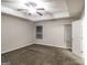 A spacious bedroom features a tray ceiling, soft carpet, and two windows providing ample natural light at 323 Lauren Dr, Fairburn, GA 30213